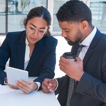 Business people using tablet computer at cafe table